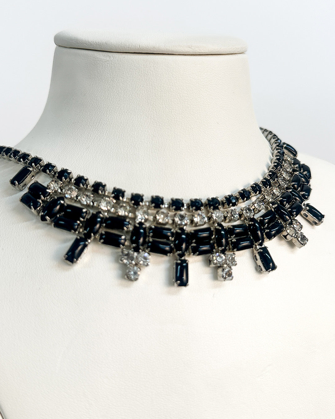 Black and silver beaded necklace on a mannequin with a white background