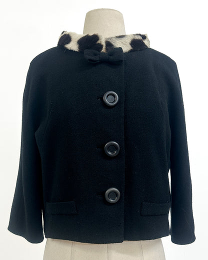 Navy blue coat with fur collar on a mannequin against a white background