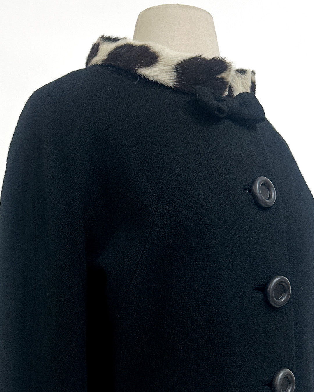 black coat with cow collar on a mannequin against a white background