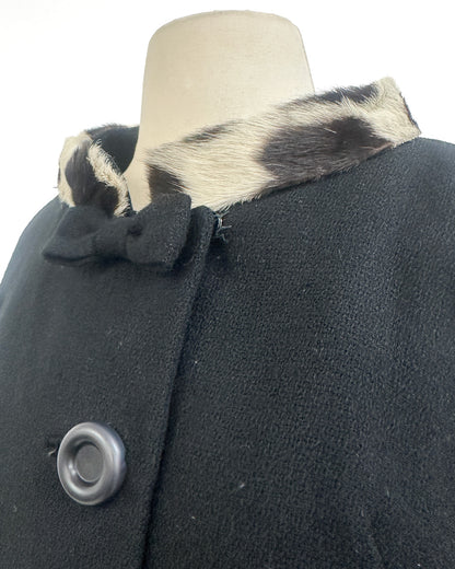 Black coat with fur collar on a mannequin against a white background