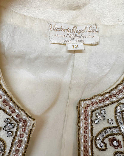 Close-up of a garment with 'Victoria Royal Ltd.' label and size tag, featuring intricate beadwork.