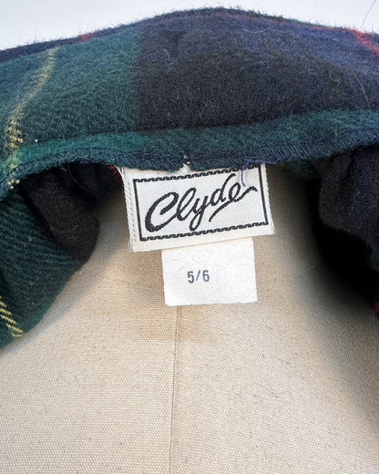 Close-up of a plaid fabric with a 'Clyde' label and size tag on a neutral background